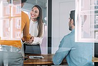 Zwei weibliche Geschäftspartnerinnen schütteln such die Hände in einem Büro